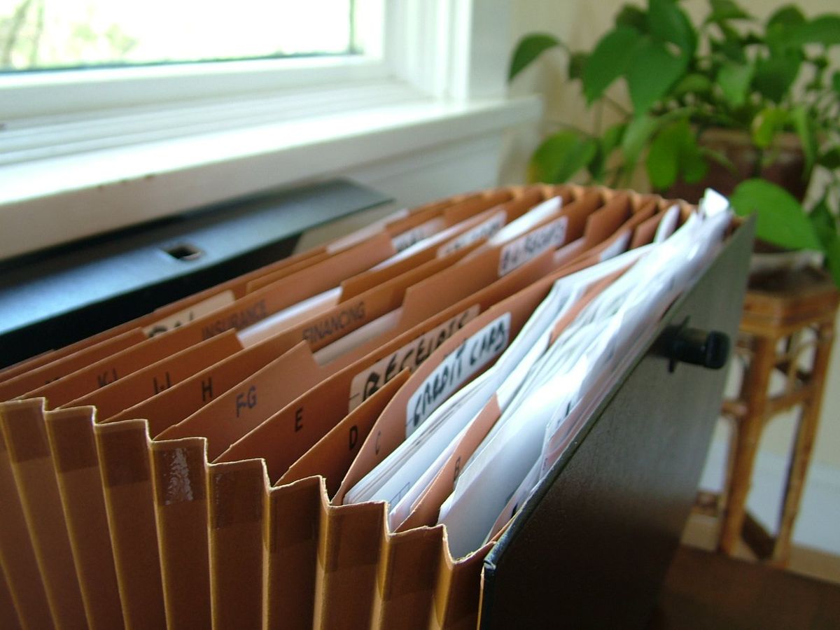 An accordion file holding labeled folders of paperwork